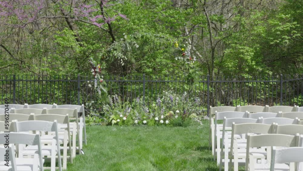 POV walking down grassy outdoor wedding venue aisle towards large floral ring altar POV walking down grassy outdoor wedding venue aisle towards large floral ring altar