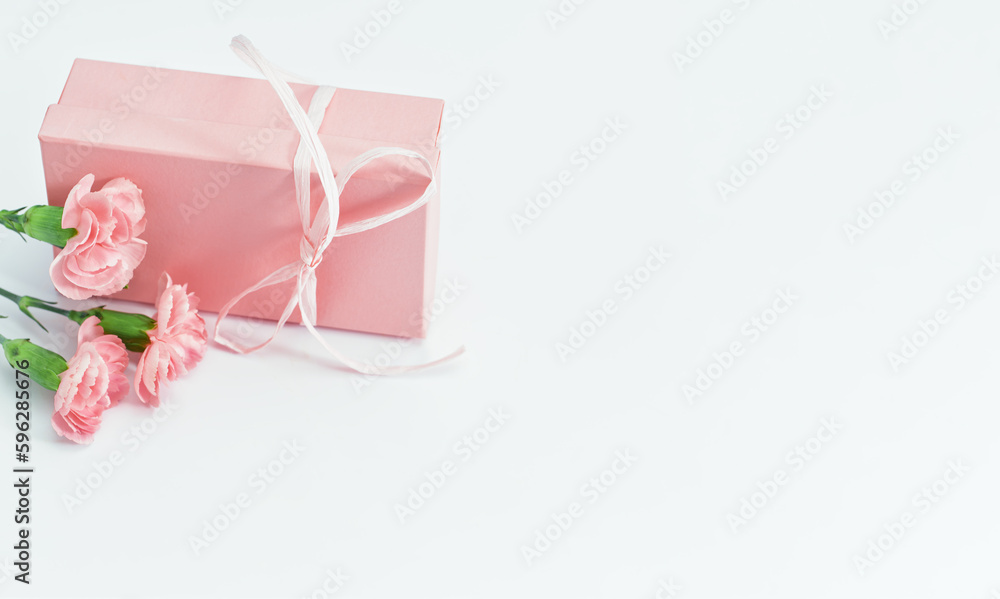 Pink gift box with tender pink carnation flowers. Gift or holiday concept. Mothers Day, birthday wedding or St Valentines day with copy space. Minimal