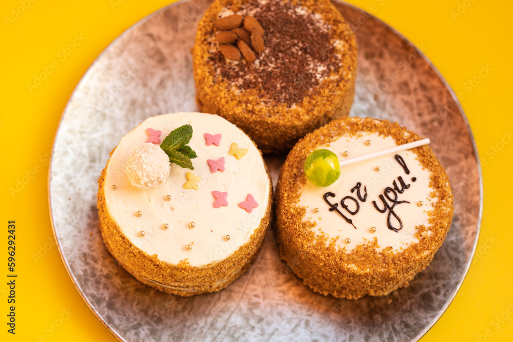 Three bento cakes with different designs on a yellow background. Three bento cakes with different designs on a yellow background.