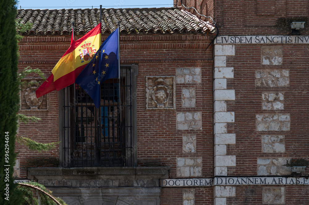 Fachada antigua con escudo y banderas de la comunidad de Madrid, España