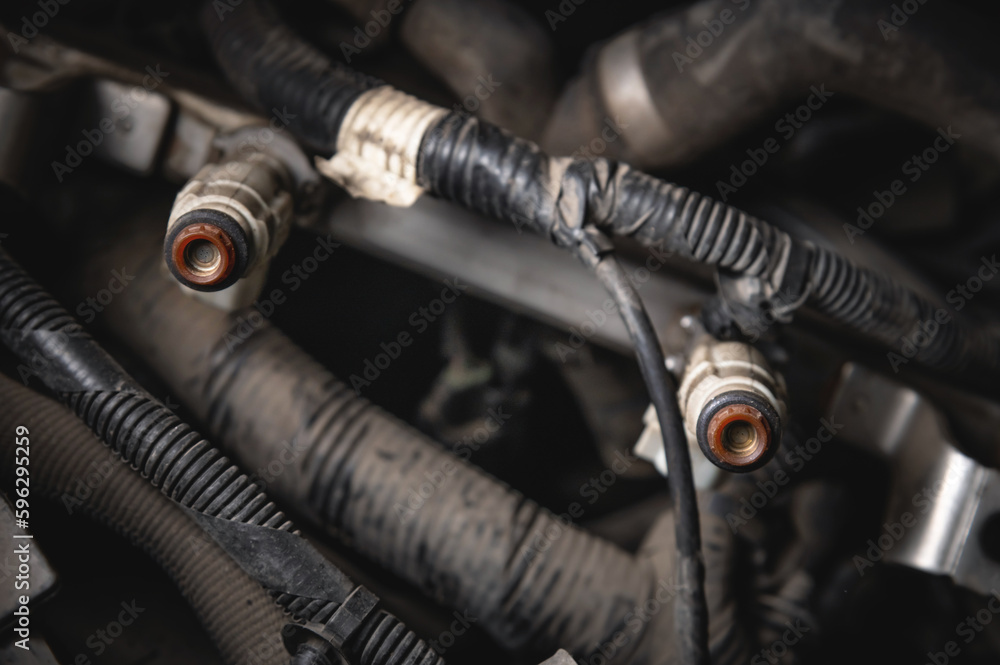 Old dirty injectors on the fuel rail in selective focus Old dirty injectors on the fuel rail in selective focus