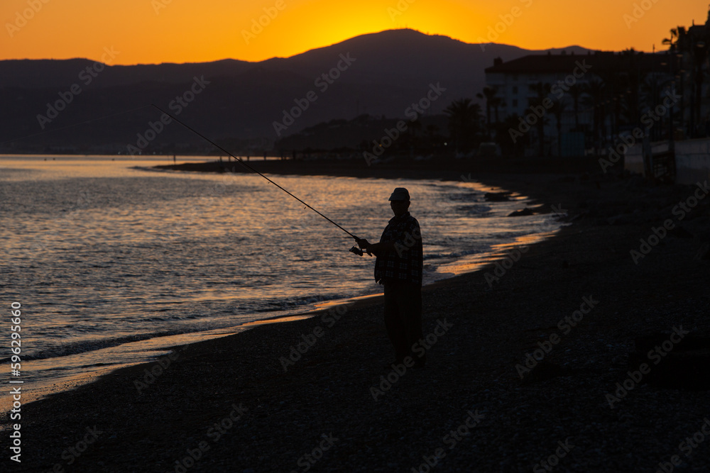 Fisherman at the beach during sunset