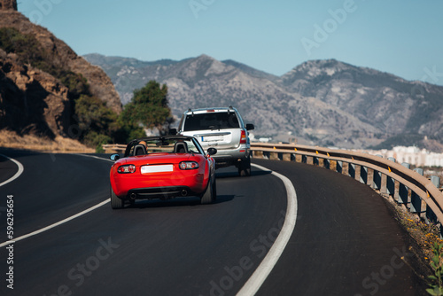 Cars go at the road trip along the sea and mountains 
