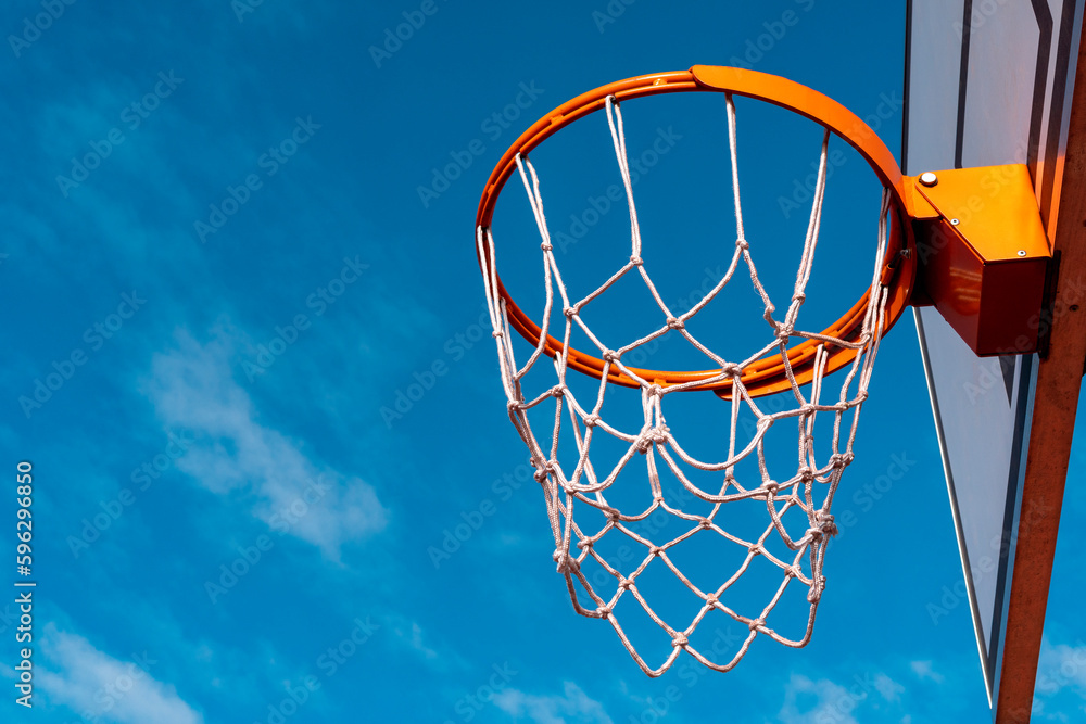 Low angle shot of basketball hoop on sunny day outside at basketball court