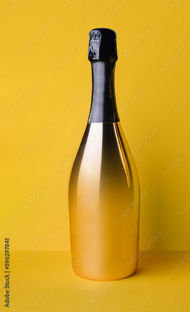 golden elegant bottle of champagne on a yellow background golden elegant bottle of champagne on a yellow background