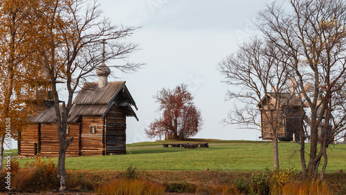 A monument of wooden architecture, a wooden church with many domes and wooden houses of peasants. Kizhi Island, Karelia, northern Russia.