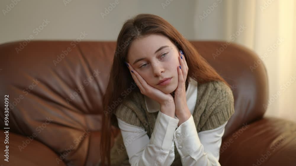 Zoom in portrait of charming teenage girl looking away dreaming sitting indoors. Live camera approaches to beautiful Caucasian teenager thinking Zoom in portrait of charming teenage girl looking away dreaming sitting indoors. Live camera approaches to beautiful Caucasian teenager thinking