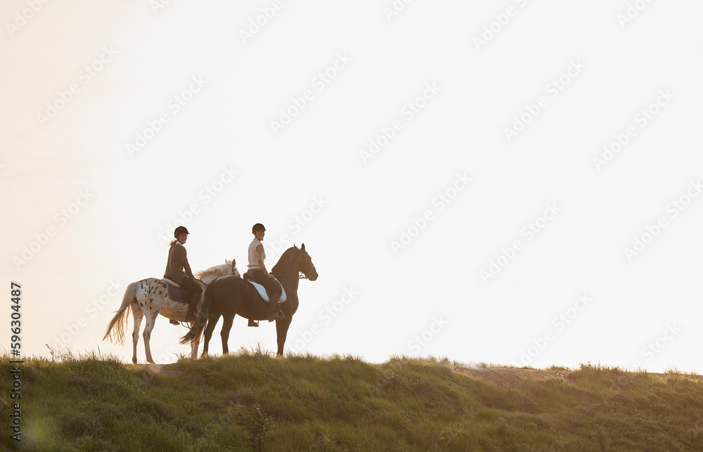 Fototapeta premium Horse riding provides such a sense of escapism and relaxation. Shot of two young women out horseback riding together.