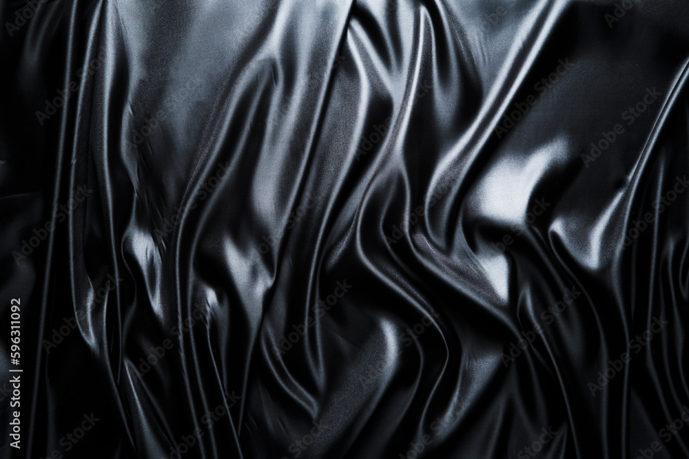 Fototapeta premium Silk fabric, abstract wavy black satin fabric background.