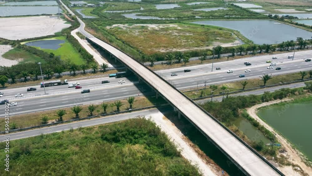 Roadway and traffic connected urban city. Aerial view of expressway infrastructure for logistic transportation. Motion car and truck on the highway in Bangkok, Thailand. Roadway and traffic connected urban city. Aerial view of expressway infrastructure for logistic transportation. Motion car and truck on the highway in Bangkok, Thailand.