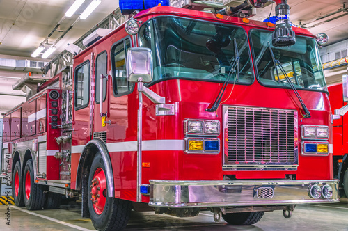 A red car with chrome body parts designed to deliver firefighters to the place of fire and to extinguish fires. Fire truck with retractable ladder for extinguishing fires at height. 