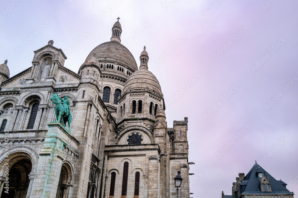 The Sacre Coeur Basilica on the hill of Montmartre in France with the pink and blue sky in the backgrounds