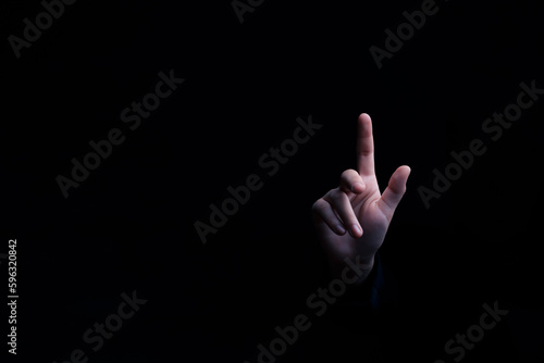 Discover the power of determination and leadership with our captivating photograph of a businessman's hand pointing to an empty space on a sleek black background. Achieve success, inspire innovation. © sawitreelyaon
