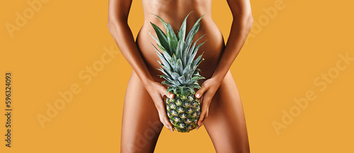  Young woman holding a pineapple in her hand