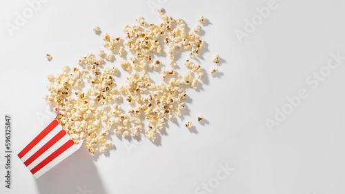 Classic striped box with delicious popcorn on white background