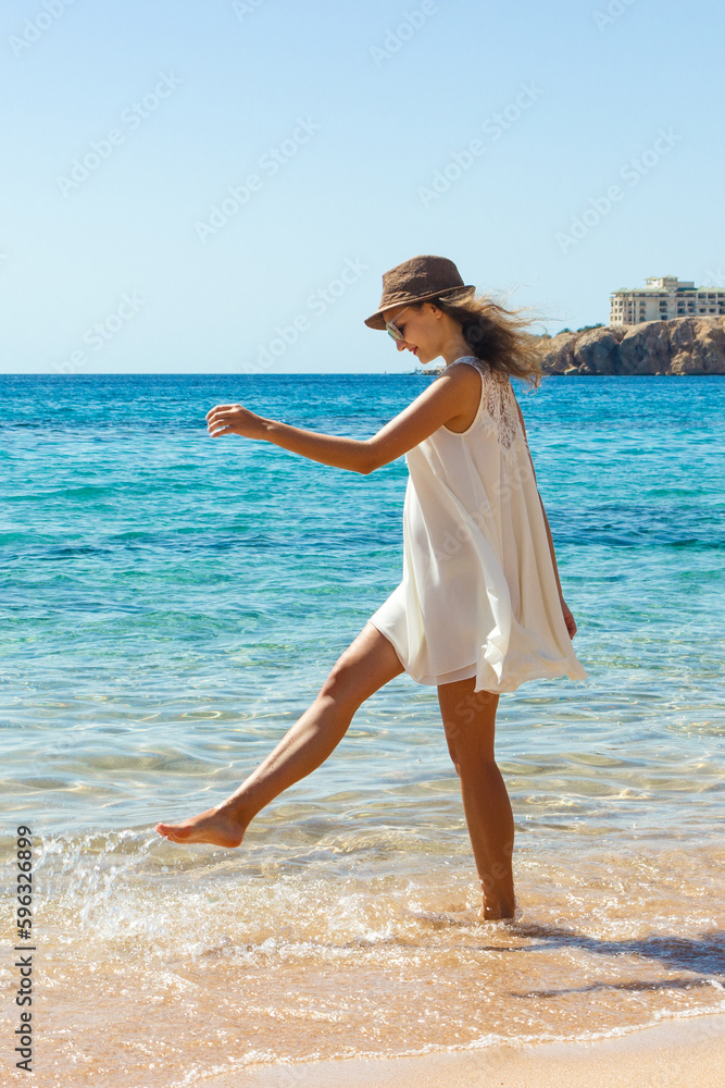 Woman relaxing at beach enjoying summer freedom. Happ girl at the beach Woman relaxing at beach enjoying summer freedom. Happ girl at the beach