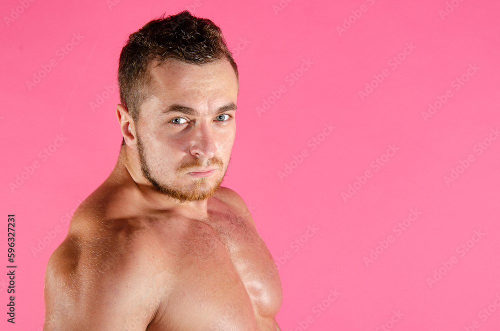Fototapeta premium Young handsome trainer posing in the studio. A man with a beautiful athletic body.