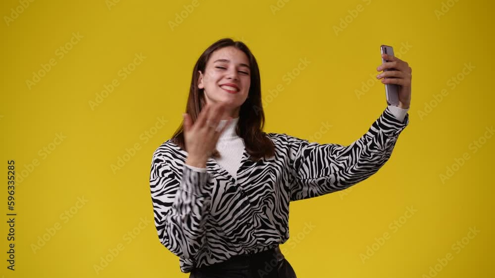 4k video of woman using her phone on yellow background. 4k video of woman using her phone on yellow background.