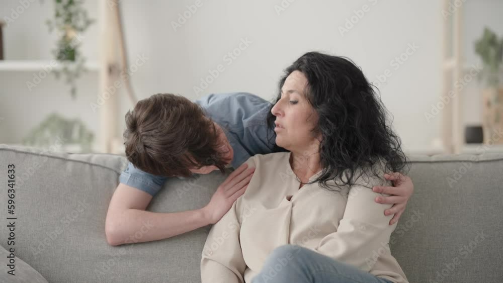 Loving teenager boy and mother talking and embracing Loving teenager boy and mother talking and embracing