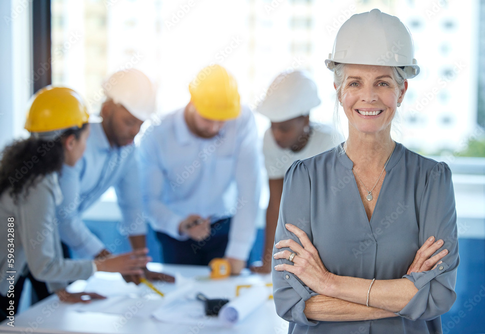 Running the construction industry. Shot of a mature businesswoman standing with her arms crossed in an office at work. Running the construction industry. Shot of a mature businesswoman standing with her arms crossed in an office at work.