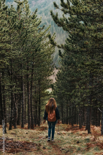 Woman Backpacker Walking in Coniferous Forest