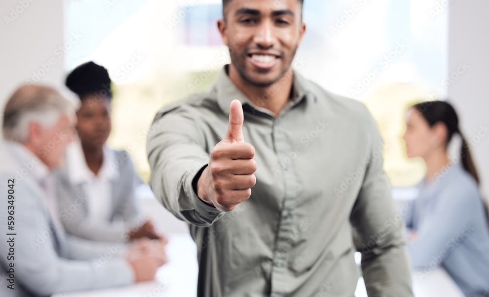 Expect nothing but the best from him. Portrait of a young businessman showing thumbs up in an office with his colleagues in the background. Expect nothing but the best from him. Portrait of a young businessman showing thumbs up in an office with his colleagues in the background.