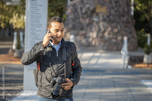 Φωτογραφία Photographer working on the street and talking with his mobile phone with copy space