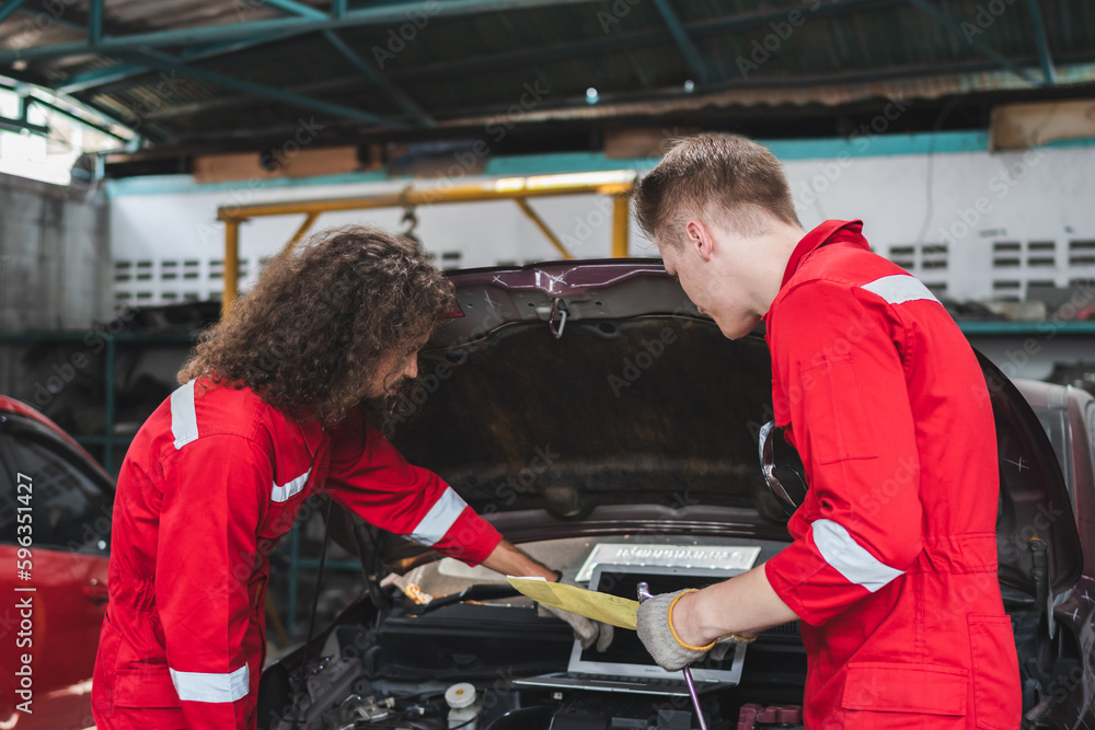 Young Caucasian car mechanic with a checklist, Mechanics in uniform are working in auto service, Technician checking modern car at garage, Car repair and maintenance concepts Young Caucasian car mechanic with a checklist, Mechanics in uniform are working in auto service, Technician checking modern car at garage, Car repair and maintenance concepts