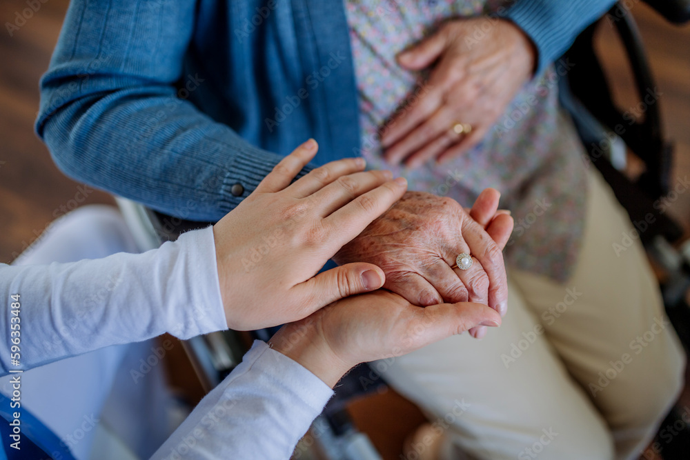 Top view of nurse stroking hands of senior woman. Top view of nurse stroking hands of senior woman.