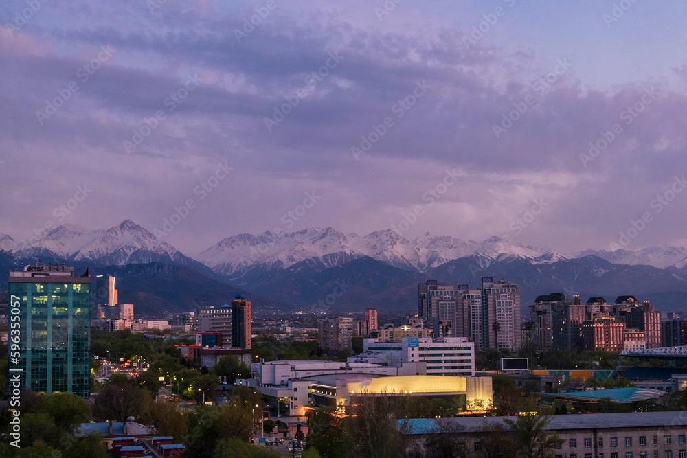 Large modern city in the mountains Alatau, sunset, beautiful landscape. Almaty, Kazakhstan. Night city. High quality photo.