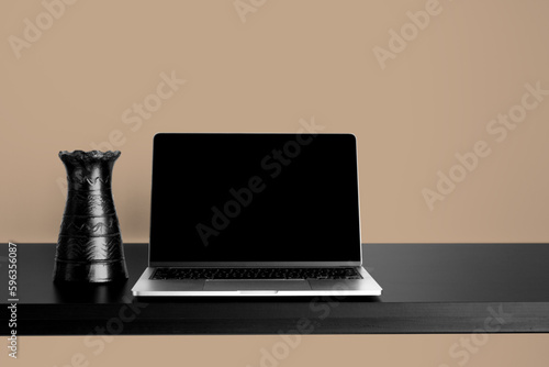 Laptop Mockup on black wooden table with changeable desktop background. Paired with black vase and Brown background.