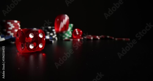 Closeup of falling red dice and casino chips on black background. Gambling and entertainment concept poker and gambling photo