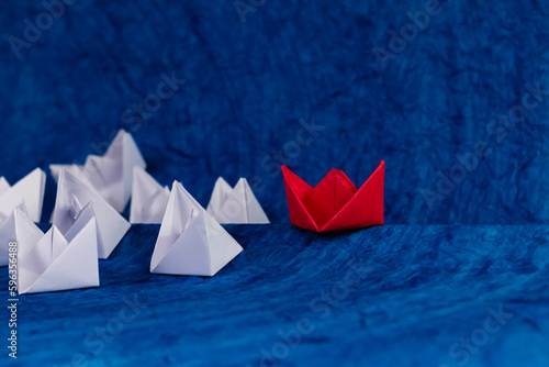 Photography Low angle shot of a red and white paper boats sailing in sea made with blue textured paper