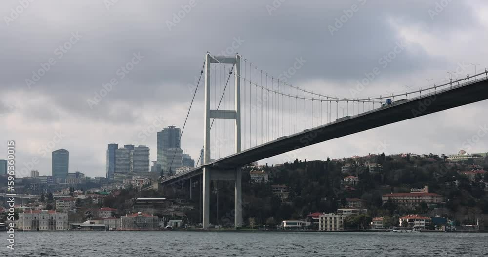 Bosphorus bridge in Istanbul with car traffic, skyscrapers against the backdrop of city skyline. Turkey shipping canal and beautiful large modern bridge across sea Bosphorus bridge in Istanbul with car traffic, skyscrapers against the backdrop of city skyline. Turkey shipping canal and beautiful large modern bridge across sea