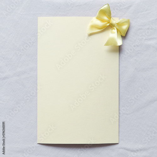 Blank greeting card, invitation and envelope mockup. Minimal frame with yellow satin bow. Flat lay, top view. Happy mother's day, women's day or birthday, wedding composition. Square