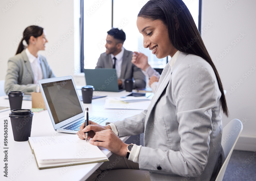 Shes always highly organised. Shot of a young businesswoman working on a laptop and writing notes during a meeting in an office. Shes always highly organised. Shot of a young businesswoman working on a laptop and writing notes during a meeting in an office.