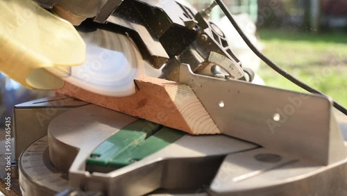 Wallpaper Mural A man uses an electric circular saw to cut wooden bars. Carpenter works on a board outdoors, close-up Torontodigital.ca