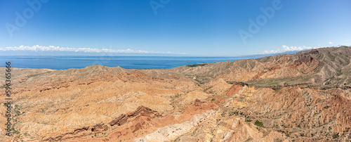 The beautiful wasteland of Skazka Canyon with Lake Issyk-Kul in the background in Kyrgyzstan.