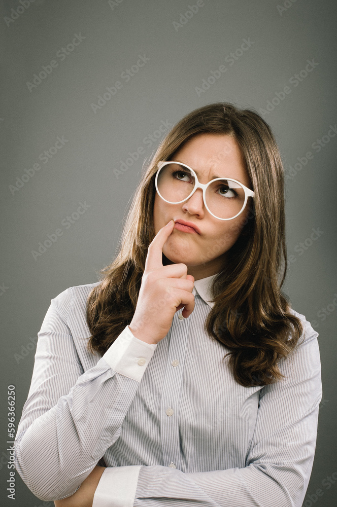Her brain is ticking. Shot of a young woman in thought against a studio background. Her brain is ticking. Shot of a young woman in thought against a studio background.