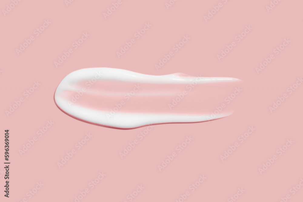 A dab of cosmetic cream. Light, smooth surface. Texture of spreadable cream. Liquid cream smear. On a pink background. A dab of cosmetic cream. Light, smooth surface. Texture of spreadable cream. Liquid cream smear. On a pink background.
