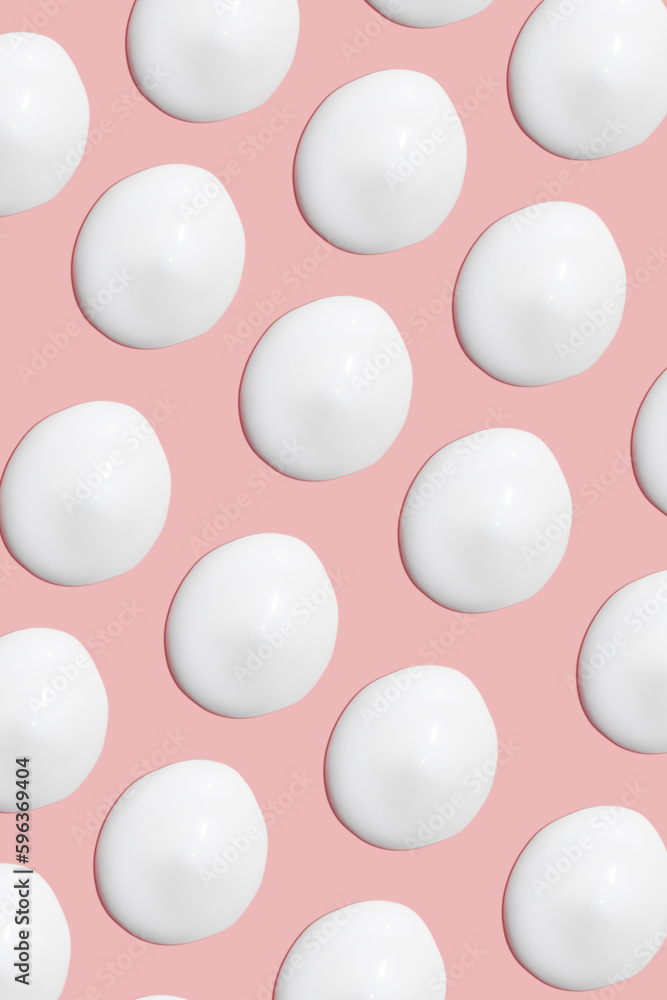 Lots of smears of cosmetic cream. Light, smooth surface. Texture of spreadable cream. Liquid creamy strokes. On a pink background. Cosmetic background, banner. Lots of smears of cosmetic cream. Light, smooth surface. Texture of spreadable cream. Liquid creamy strokes. On a pink background. Cosmetic background, banner.