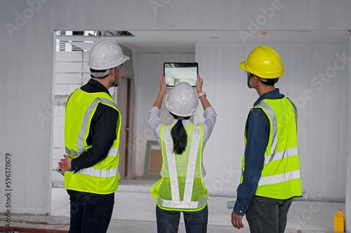 Engineer, architect and construction supervisor Use tablet to record information while inspecting construction work. Construction supervisor, architect or engineer inspect construction inside building photo