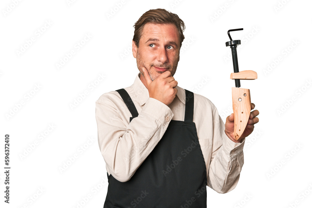 A middle-aged shoe maker looking sideways with doubtful and skeptical expression. A middle-aged shoe maker looking sideways with doubtful and skeptical expression.
