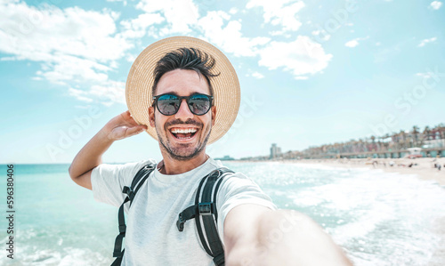 Photography Happy man with hat and sunglasses taking selfie picture with smartphone at the b