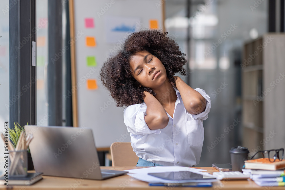 Obraz premium Portrait of tired young business african american woman work with documents tax laptop computer in office. Sad, unhappy, Worried, Depression, or employee life stress concept 