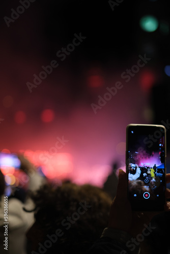 Mobile phone recording vertically at a concert red lights 