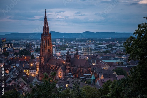 Blick auf die Stadt Freiburg (Deutschland) von oben bei Sonnenuntergang und aufziehendem Gewitter über den Vogesen