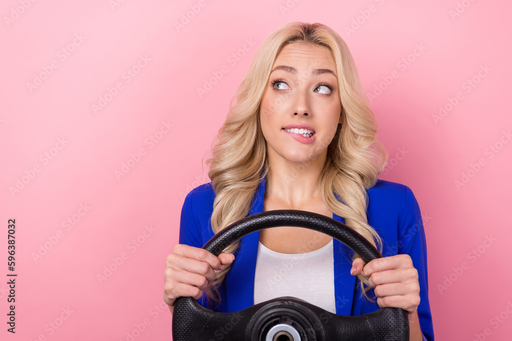Portrait of worried minded person hands hold wheel biting lips look empty space isolated on pink color background Portrait of worried minded person hands hold wheel biting lips look empty space isolated on pink color background