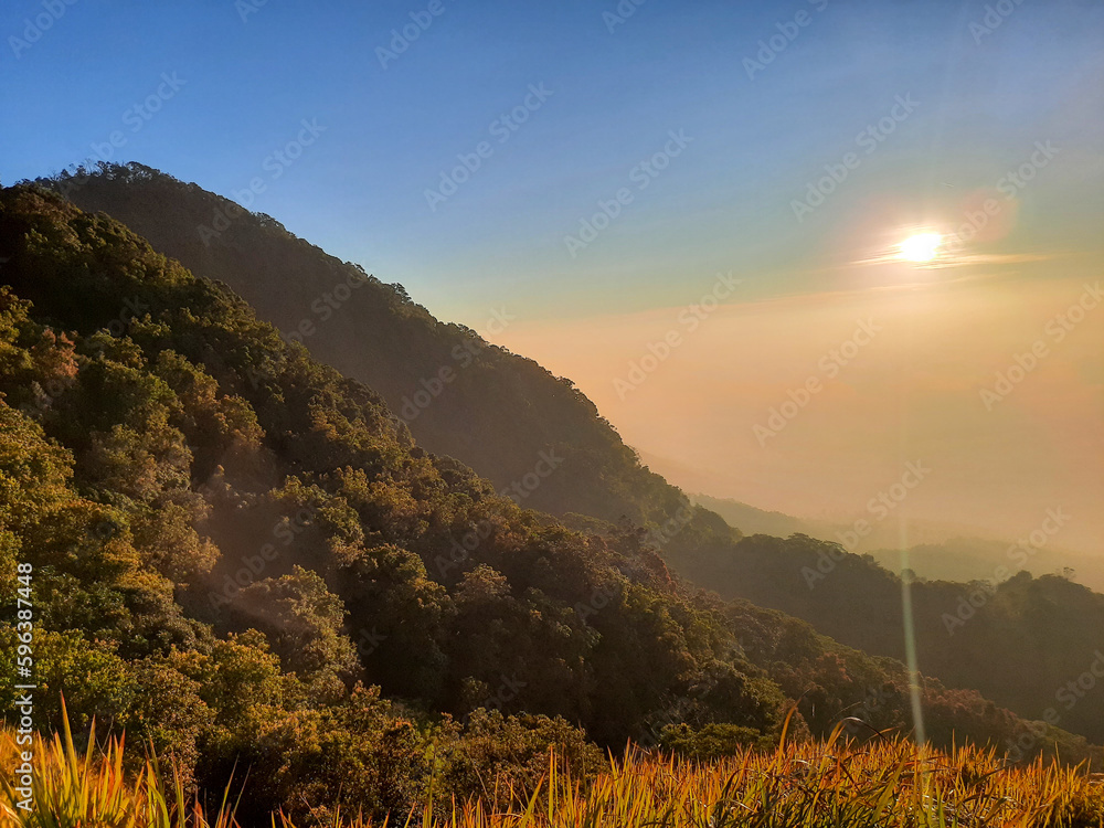 View of the hill at the top. hill with a shining sun. Sunrise at the top. Mountain peaks with hills. High hill. Silhouette. View of the hill at the top. hill with a shining sun. Sunrise at the top. Mountain peaks with hills. High hill. Silhouette.