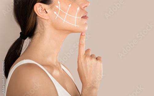 Fototapeta Side view of unrecognizable lady with lifting arrows on cheek